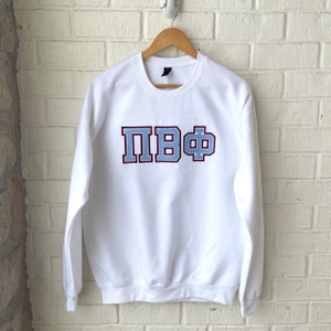 May include: White sweatshirt with a blue and maroon embroidered Greek letter design that reads "ПВФ".