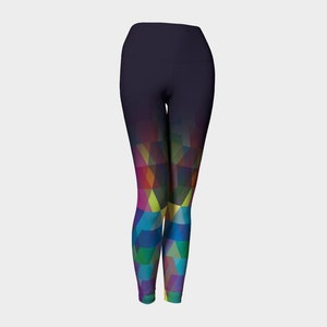 Op de afbeelding: Zwarte yogaleggings met een kleurrijk geometrisch patroon op de onderbenen. Het patroon is een verloop van roze, paars, blauw, groen, geel en oranje.