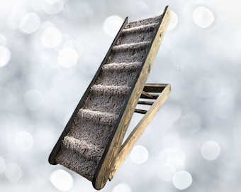May include: A wooden pet ramp with a carpeted surface. The ramp is angled and has a black trim around the edge. The ramp is made of wood and has a natural finish.