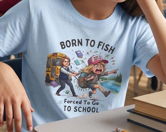 May include: A light blue t-shirt featuring a graphic illustration of a person being pulled toward a school bus by another individual, with the text BORN TO FISH FORCED TO GO TO SCHOOL printed in black above and below the colorful cartoon scene.