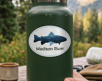 May include: A matte olive green insulated water bottle with a black screw-top lid. The bottle features a white oval sticker with a blue fish silhouette and the text Madison River. The brand name Hydro Flask is printed in white at the base.