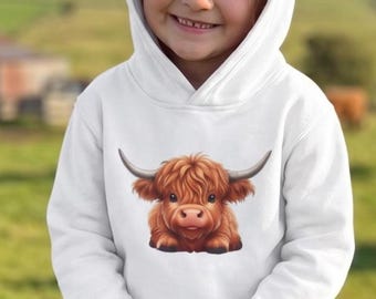 May include: A white hooded sweatshirt featuring a graphic print of a brown Highland cow on the chest. The hoodie has long sleeves and a front pocket, paired with blue denim jeans and patterned slip-on shoes, creating a casual outfit.