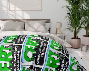 May include: A blanket with a repeating pattern of the words "ERT" in large green letters, with the words "COMMUNITY EMERGENCY RESPONSE TEAM" in black and white rectangles. The blanket is draped over a bed.
