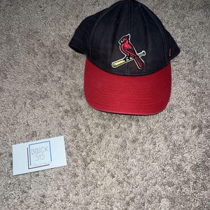 Könnte beinhalten: Eine schwarz-rote Baseballkappe mit einem roten Kardinalvogel-Logo. Die Kappe hat einen gebogenen Schirm und eine strukturierte Krone. Das Logo ist in Rot, Gelb und Weiß gestickt. Ein klassisches Sportaccessoire.