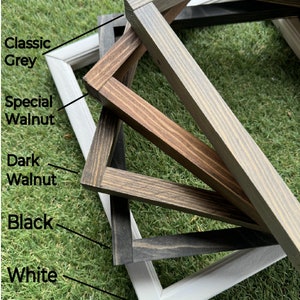 May include: Five wooden picture frames in different colors, stacked on top of each other. The frames are in the following order from top to bottom: Classic Grey, Special Walnut, Dark Walnut, Black, and White.