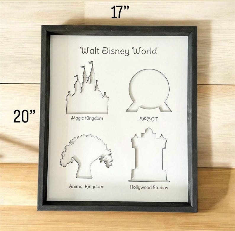 May include: Black framed wall art with a white background and cut-out silhouettes of the four Walt Disney World theme parks: Magic Kingdom, Epcot, Animal Kingdom, and Hollywood Studios. The art measures 20 inches by 17 inches.