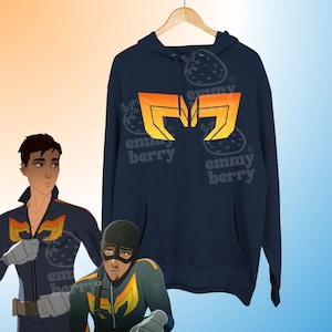 May include: A dark navy blue hooded sweatshirt featuring a large, stylized orange and yellow geometric emblem on the chest. The design includes a front kangaroo pocket, long sleeves, and a hood with matching drawstrings, displayed on a wooden hanger.