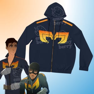 Op de afbeelding: Marineblauwe hoodie met ritssluiting en een grote oranje en gele afbeelding. De hoodie heeft een capuchon met een aardbeilogo en oranje strepen op de schouders. Een bijpassend jumpsuit is ook zichtbaar.