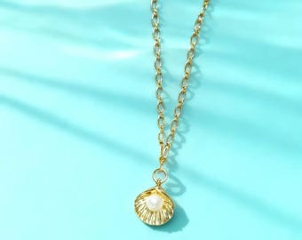 May include: A gold-toned necklace featuring a delicate chain and a pendant shaped like an open seashell. The seashell pendant contains a single, small, round white pearl at its center. The metal has a polished finish.