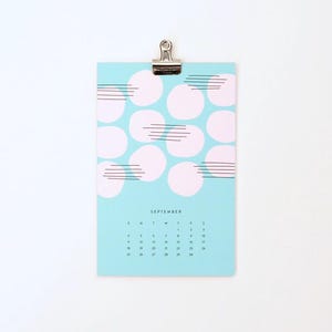 May include: A light blue calendar with a pink and black abstract design. The calendar is for September and has the days of the week and numbers for each day of the month.