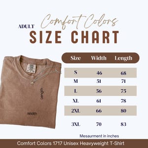 May include: A brown Comfort Colors 1717 Unisex Heavyweight T-Shirt with a size chart. The chart shows sizes S to 3XL, with width and length measurements in inches. The shirt has a crew neck and a small tag.
