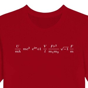May include: Red t-shirt with white mathematical equations printed across the chest. The equations include symbols and fractions. The shirt has short sleeves and a crew neck.