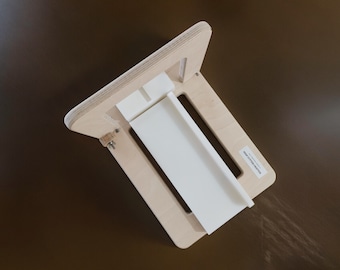 May include: A wooden soap making mold with a white plastic insert. The mold is made of light wood and has a simple design. The mold is designed to make rectangular bars of soap.