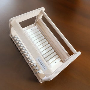 May include: A wooden soap cutter with a white plastic insert and 10 metal hooks. The soap cutter is labeled "SOAP CUTTER TRAY".