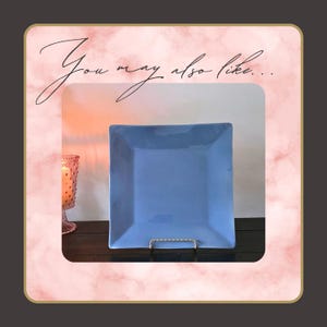 May include: A square, light blue plate displayed on a silver metal stand. The plate is the focal point, with a soft pink and white background and the text "You may also like..." in cursive.