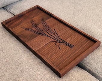 May include: A rectangular dark brown wooden serving tray featuring a laser-engraved design of three wheat stalks on its surface. The tray has a raised border around the perimeter and displays a natural wood grain pattern throughout the flat base.