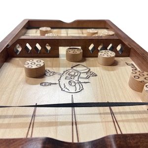 May include: Wooden tabletop game with a light wood playing surface and dark wood frame. The game features wooden pucks and a laser-etched cartoon character. The game is designed for two players.