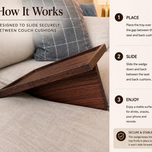May include: A dark brown wooden couch tray with a wedge base designed to slide between cushions. The text reads: How It Works, Designed to slide securely between couch cushions, 1 Place, 2 Slide, 3 Enjoy, Secure & Stable. The tray provides a flat surface.