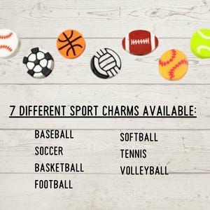 May include: Seven sports-themed charms, including a baseball, soccer ball, basketball, football, volleyball, softball, and tennis ball. The text "7 DIFFERENT SPORT CHARMS AVAILABLE:" is displayed below the charms.