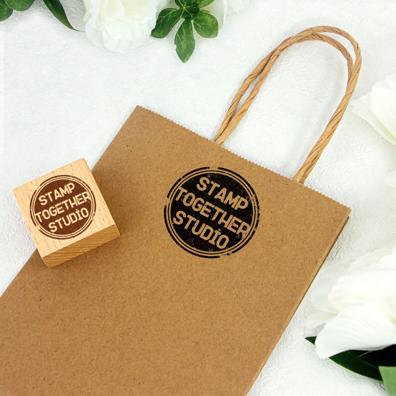 May include: A brown paper bag with a woven handle. The bag has a black and white rubber stamp that says "Stamp Together Studio". There is a smaller wooden block with the same stamp on it.