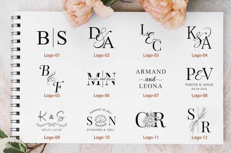 Peut inclure: Un cahier &agrave; spirales blanc pr&eacute;sente divers logos &agrave; l'encre noire. Les logos comportent des initiales, des noms et des dates, avec des accents floraux et en forme de coquillage. Des fleurs couleur p&ecirc;che ornent le cahier.