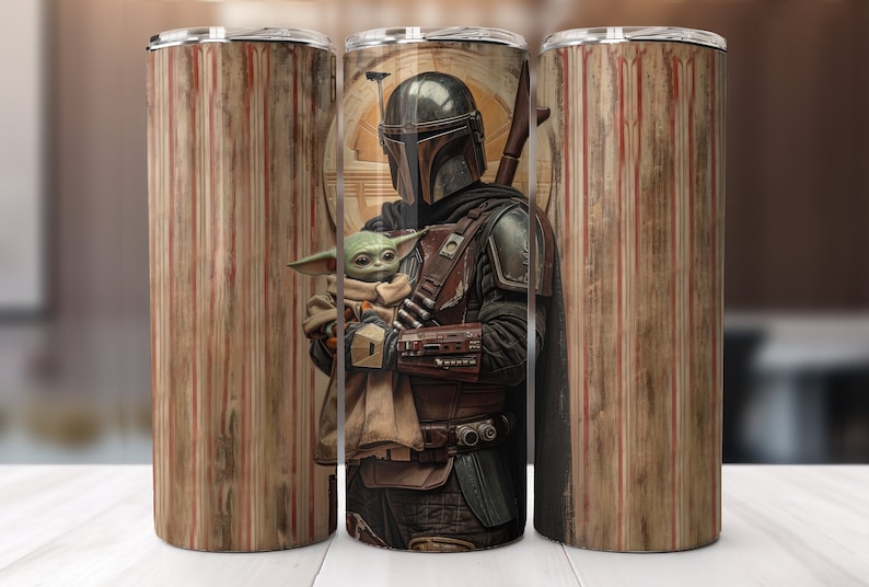 Puede incluir: Un vaso de acero inoxidable con un gr&aacute;fico de un personaje mandaloriano sosteniendo una peque&ntilde;a criatura verde. El fondo es un patr&oacute;n de veta de madera con rayas rojas y blancas.