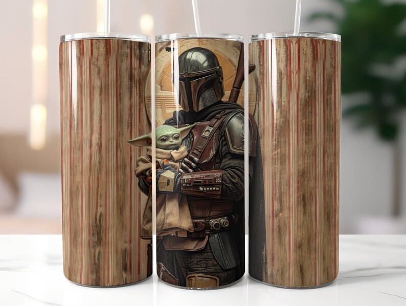 Puede incluir: Un vaso de acero inoxidable con un dise&ntilde;o de rayas marrones y rojas. El vaso presenta un gr&aacute;fico de un personaje mandaloriano sosteniendo una peque&ntilde;a criatura alien&iacute;gena verde.