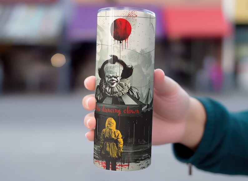 May include: A stainless steel tumbler with a graphic of Pennywise the Dancing Clown from the movie "IT". The graphic features Pennywise in a red balloon, a circus tent, and a child in a yellow raincoat.