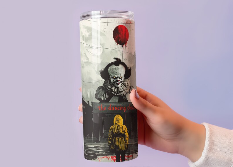 May include: A stainless steel tumbler with a graphic of Pennywise the Dancing Clown from the movie "IT". The graphic shows Pennywise holding a red balloon and a child in a yellow raincoat looking up at him. The text "the dancing clown" is printed on the tumbler.