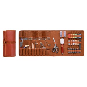 May include: A brown leather tool roll, unrolled to display various craft tools. The roll includes scissors, needles, thread spools, and other small tools. The roll is tied with a matching leather strap.