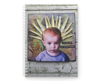 May include: A colorful journal cover with a photo of a young child with a crown of yellow paper leaves. The text "go out and make things happen" is printed on the cover.