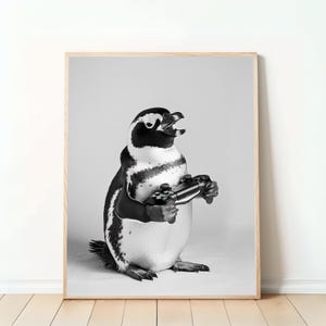 Könnte beinhalten: Schwarz-Weiß-Druck eines Pinguins, der einen Videospiel-Controller hält. Der Pinguin ist in einer spielerischen Pose mit offenem Mund dargestellt. Ein humorvolles Bild.