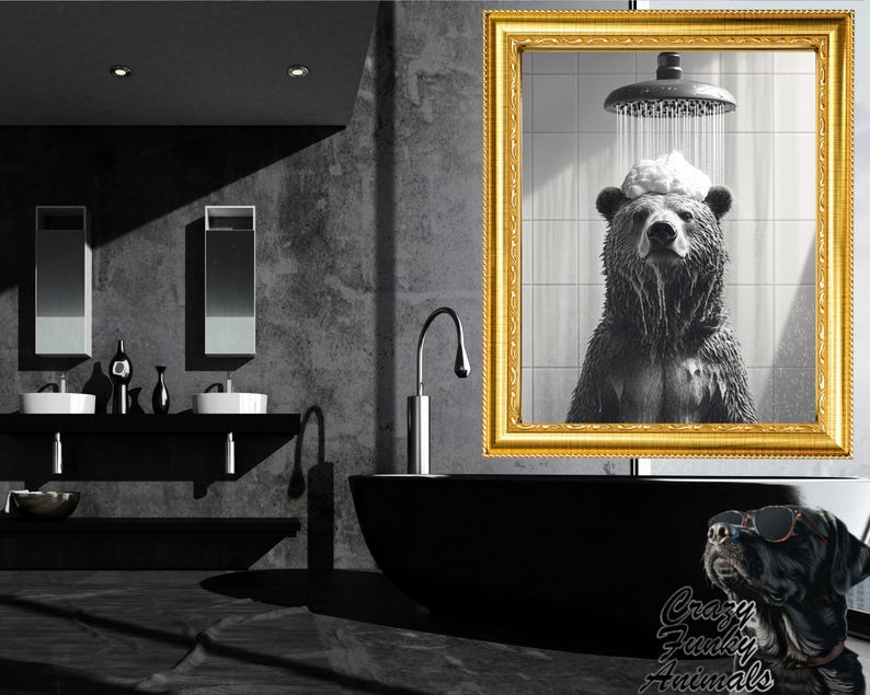 Op de afbeelding: Een zwart-witfoto van een beer die doucht. De beer staat in een douchecabine met water dat over zijn hoofd stroomt. De foto is ingelijst in een gouden lijst en hangt aan een muur in een badkamer.