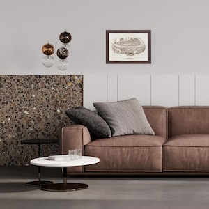 May include: A modern living room featuring a brown leather sofa with two decorative pillows. A framed architectural drawing hangs on the wall. A white and black coffee table sits in front of the sofa, and a decorative light fixture hangs from the ceiling.