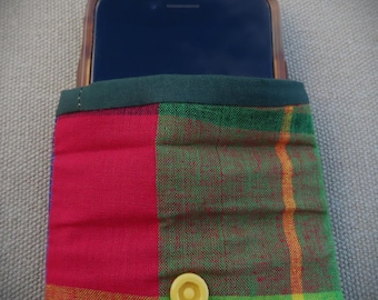 May include: A red, green and yellow plaid phone case with a yellow button. The case is made of fabric and has a dark green trim.