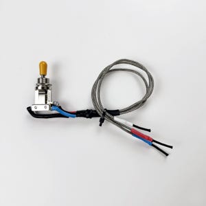 May include: A silver toggle switch with a yellow knob and three wires with black, blue, and red insulation. The wires are wrapped in a silver braided sleeve.