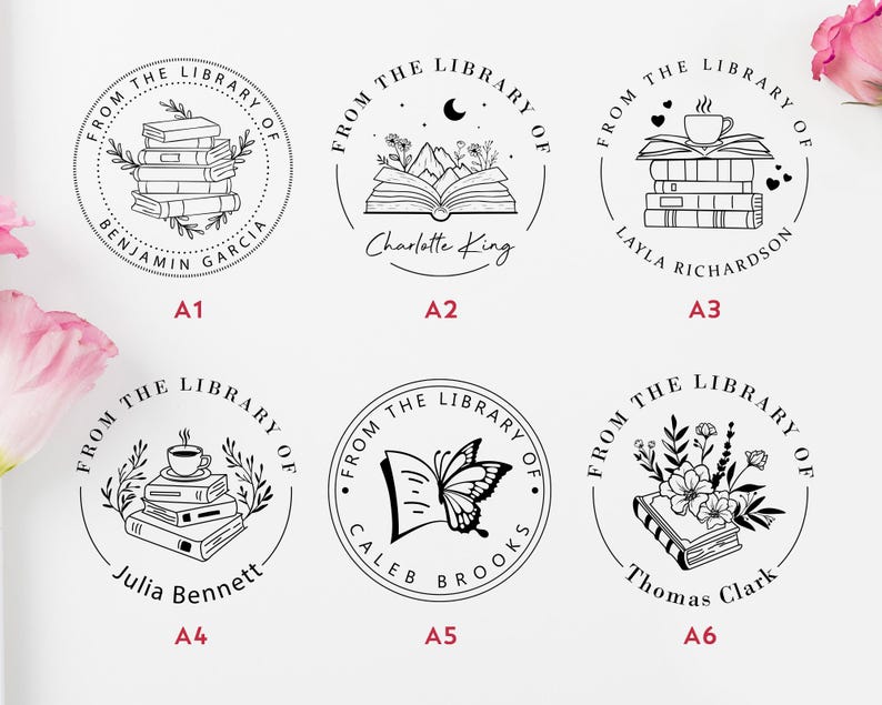 May include: Six black and white illustrations of book-themed rubber stamps. Each stamp features a different design, including a stack of books, an open book with mountains and a crescent moon, a stack of books with a coffee cup, an open book with a butterfly, a stack of books with a coffee cup and leaves, and a stack of books with flowers. Each stamp includes the text "From the Library of" and a name.