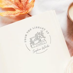 May include: A gray and white book stamp with the text "From the Library of Sophia White" and a drawing of a stack of books with flowers on top.