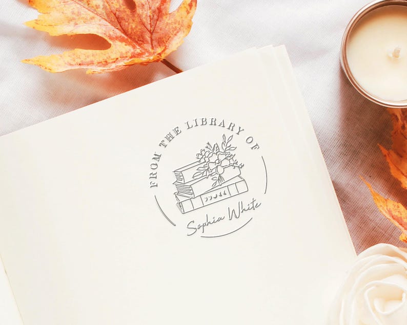 May include: A gray and white book stamp with the text "From the Library of Sophia White" and a drawing of a stack of books with flowers on top.