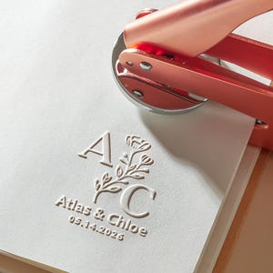 May include: A white ceramic mug with a black handle and the text "But First, Coffee" in a bold, black font. The mug is set against a blurred background, suggesting a cozy setting.