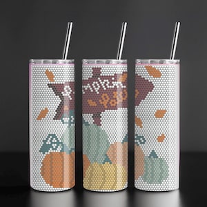 May include: Three stainless steel tumblers with lids and straws. Each tumbler features a white background with a honeycomb pattern and a fall-themed design of pumpkins and leaves. The middle tumbler has the word "Pumpkin" on it.