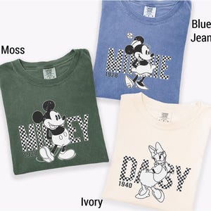 three t-shirts with Disney characters, including Mickey Mouse and Minnie Mouse, printed on them.