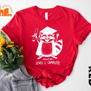 a red shirt with a raccoon on it