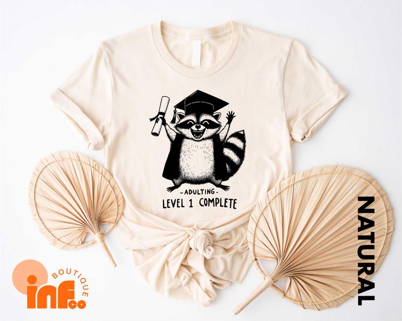 a t - shirt with a picture of a raccoon wearing a graduation cap
