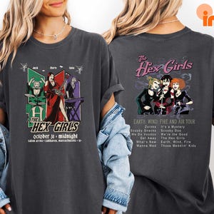 A woman wearing a black t-shirt with a graphic design featuring the band The Hex Girls and their music.