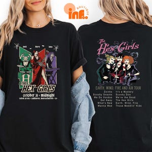 a woman wearing a black t-shirt with a graphic design of a group of people and text related to a concert or event.
