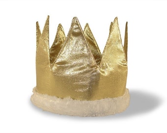 May include: A gold fabric crown with six pointed peaks. The crown has a white, fluffy trim at the base. The crown is designed to be worn on the head and is suitable for costumes or celebrations.