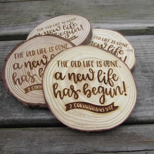 May include: Four wooden coasters with the text "The old life is gone, a new life has begun!" and the scripture reference "2 Corinthians 5:17".