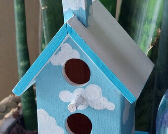 Small decorative painted birdhouse sky clouds