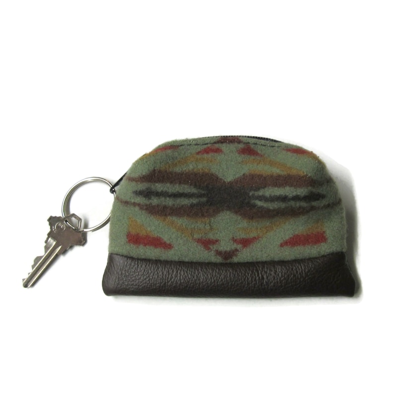 K&ouml;nnte beinhalten: Eine kleine, gr&uuml;n-braune gemusterte Geldb&ouml;rse mit braunem Lederboden und einem silbernen Schl&uuml;sselring.